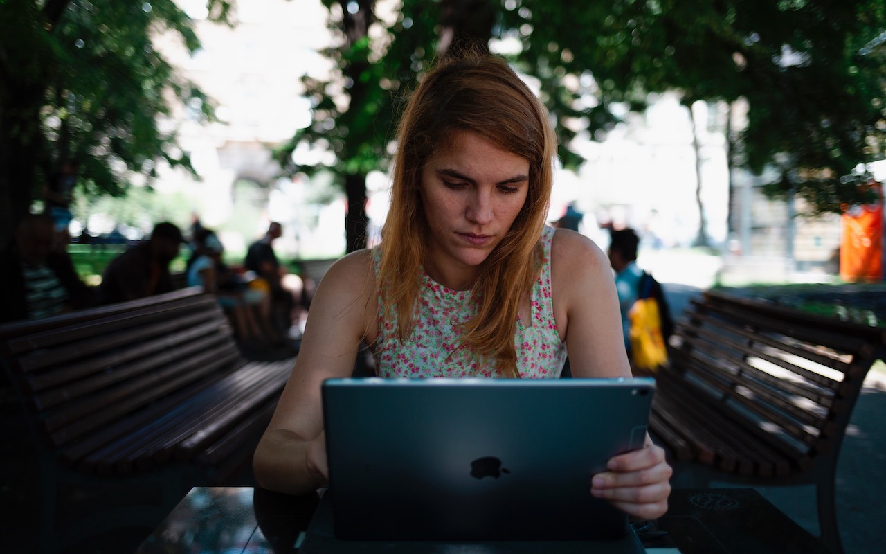 Woman checking email on iPad outdoors